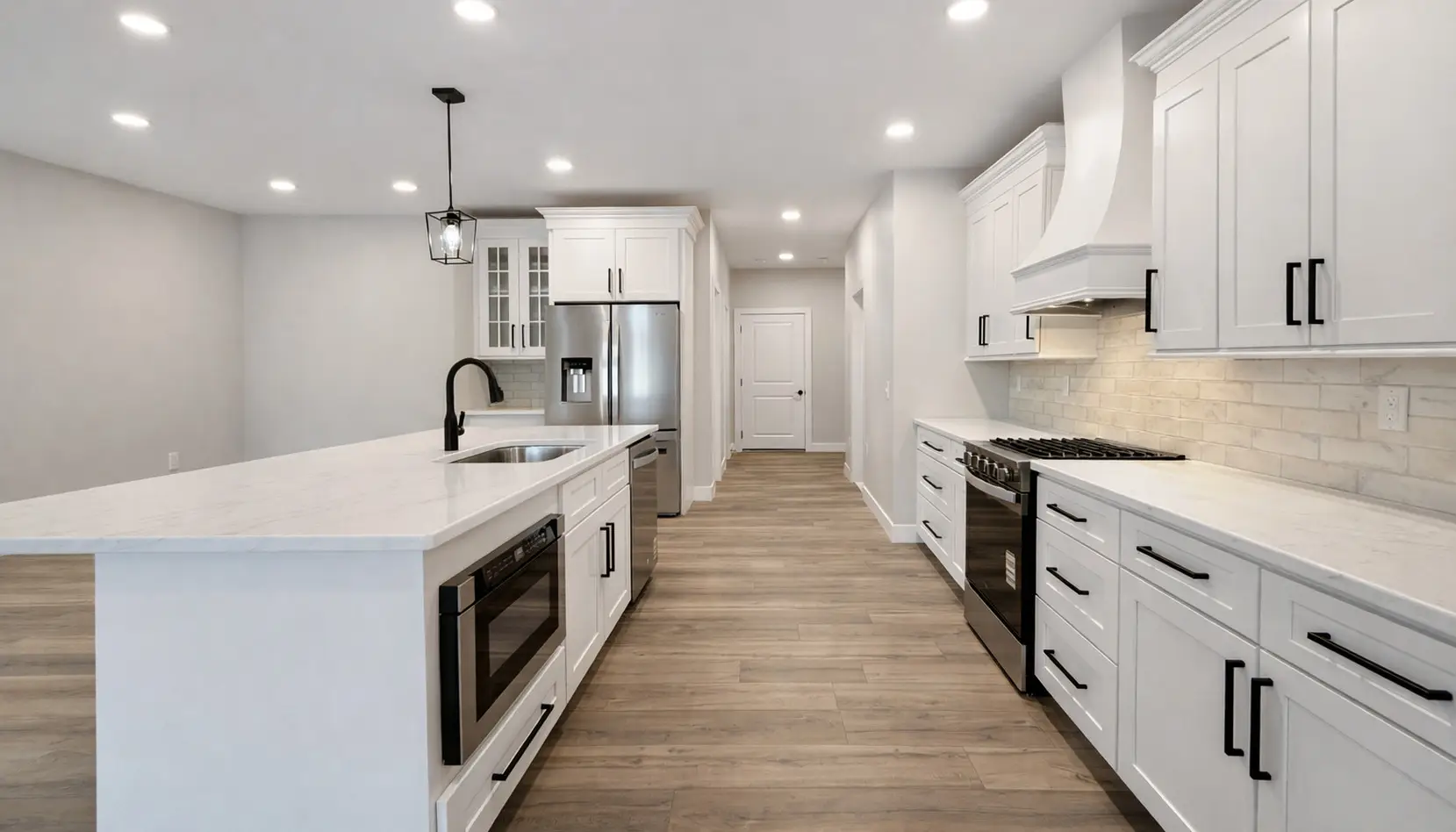 Modern Asher kitchen with white cabinets, stainless steel appliances, an island with sink and built-in microwave, wood-look flooring, under-cabinet lighting, and recessed ceiling lights