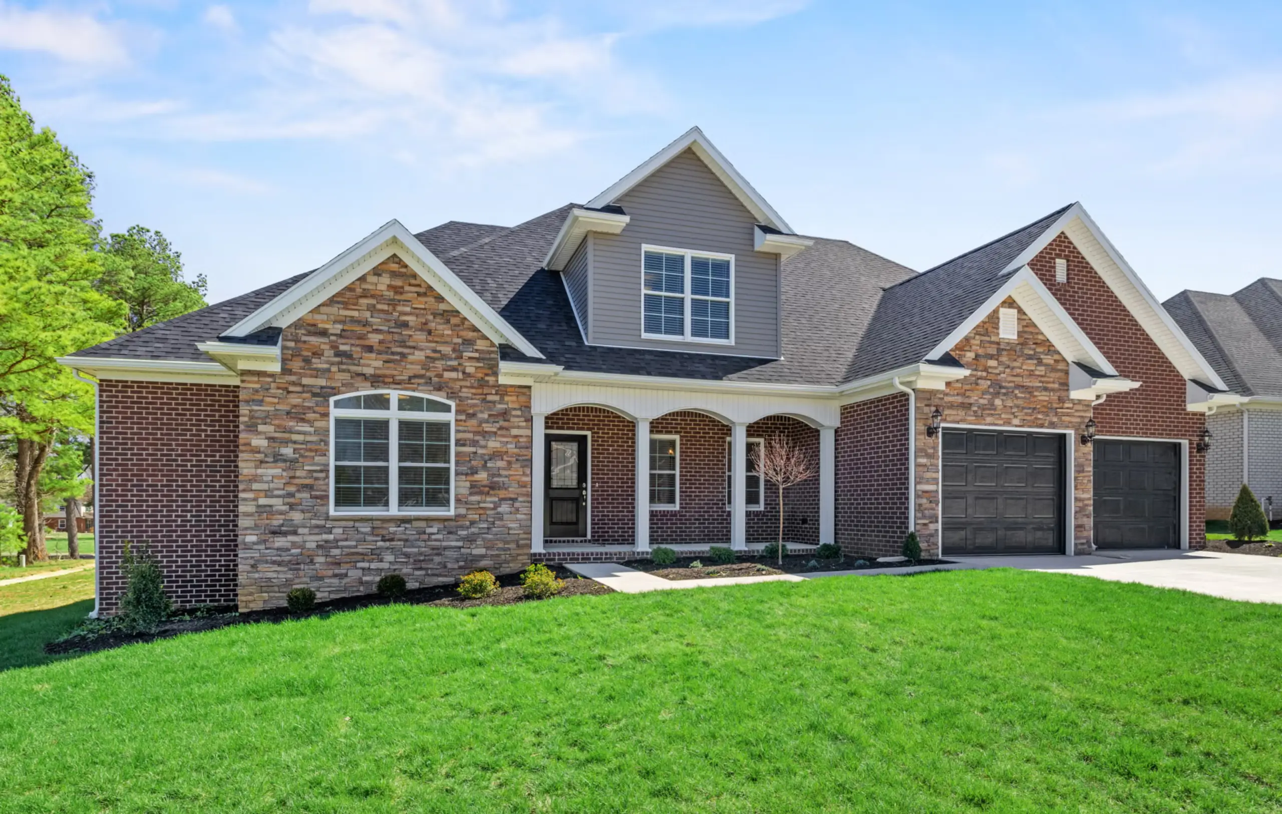 Single-story brick house in Green River Meadows with two-car garage and manicured front lawn.