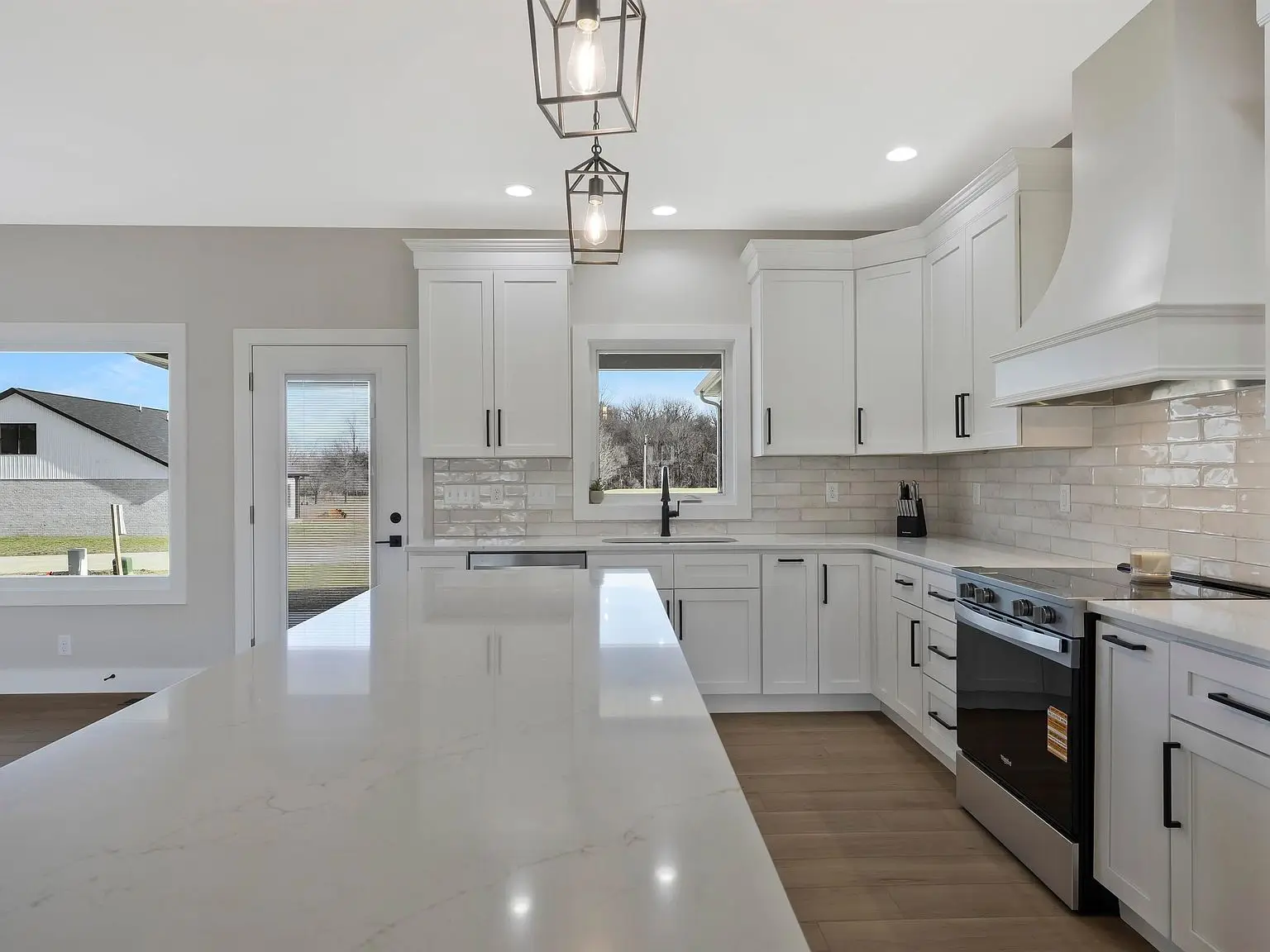 Modern kitchen in Chris Brown Homes 6100 Ashford Dr, marble island, Ava floor plan, large window.