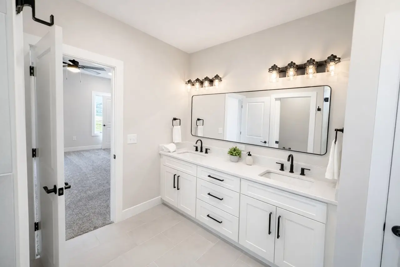 Modern bathroom with double sinks, large mirror, and Asher floor plan by Chris Brown Homes.
