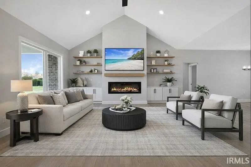 Modern living room with neutral furniture, fireplace, and large window in Ava floor plan.