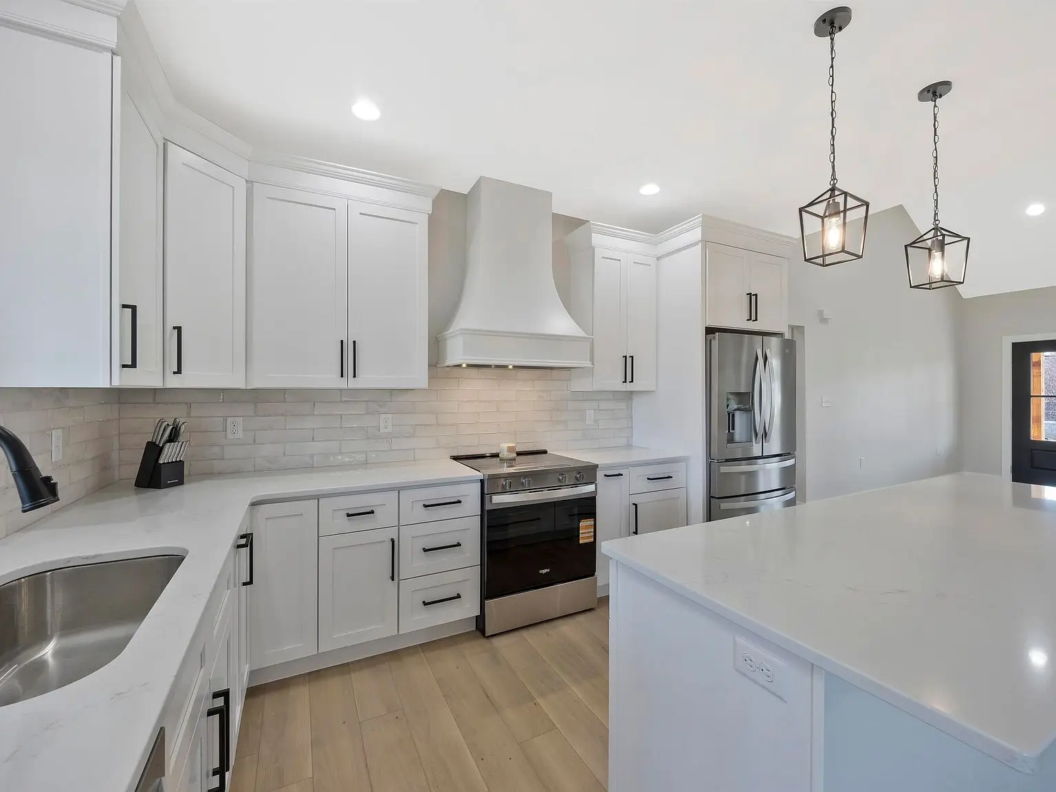 Modern kitchen in the Ava floor plan with white cabinets, island, and stainless appliances.