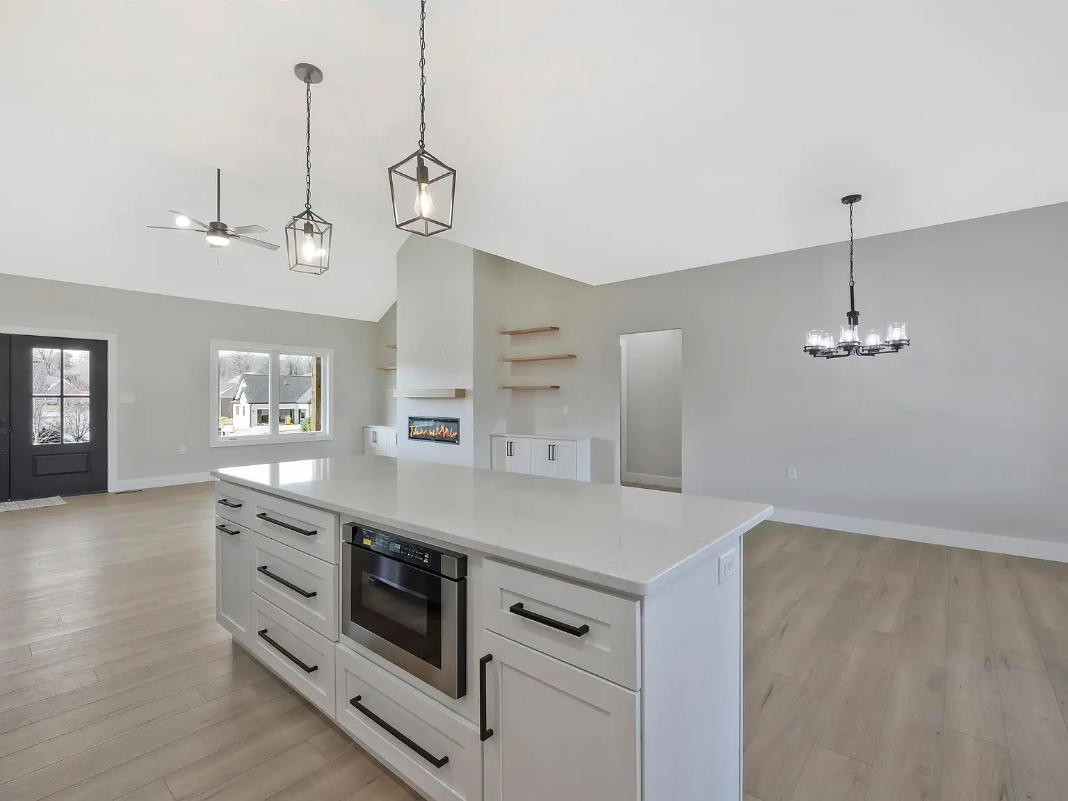 Modern kitchen with white island, pendant lights, and light wood flooring in the Ava floor plan.
