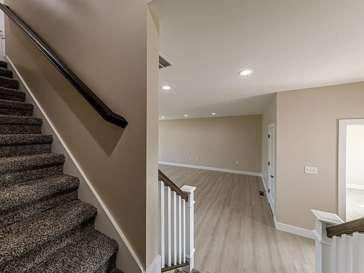 Carpeted stairs beside a room with DaVinci floor plan by Chris Brown Homes, 18739 Roscommon Rd.