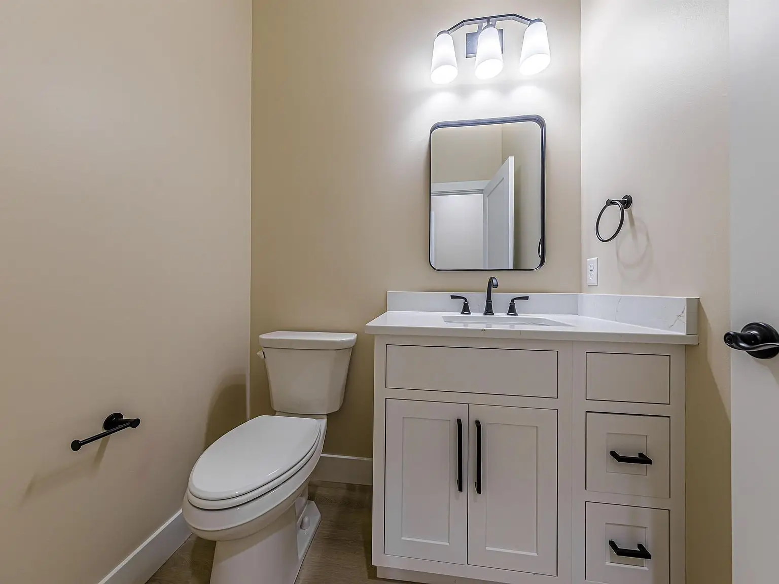 Bathroom with a toilet, white vanity, and mirror in the DaVinci floor plan by Chris Brown Homes.