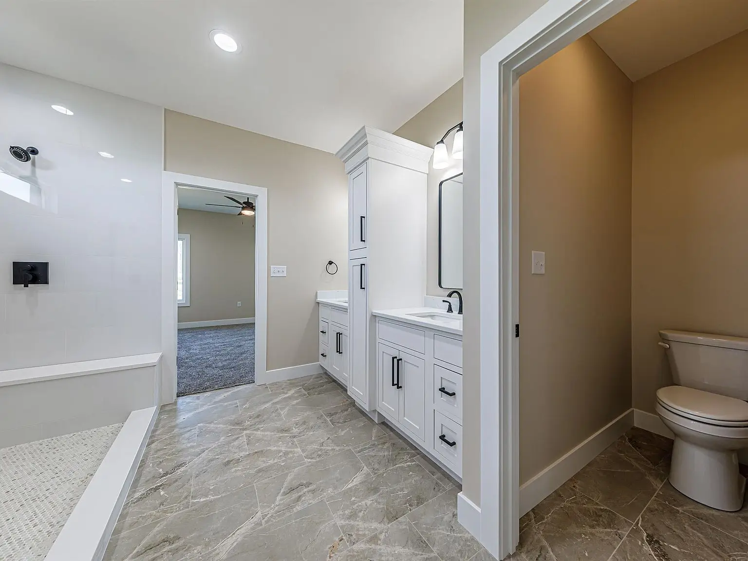 Modern bathroom with dual sinks, a shower, and the DaVinci floor plan’s enclosed toilet area.