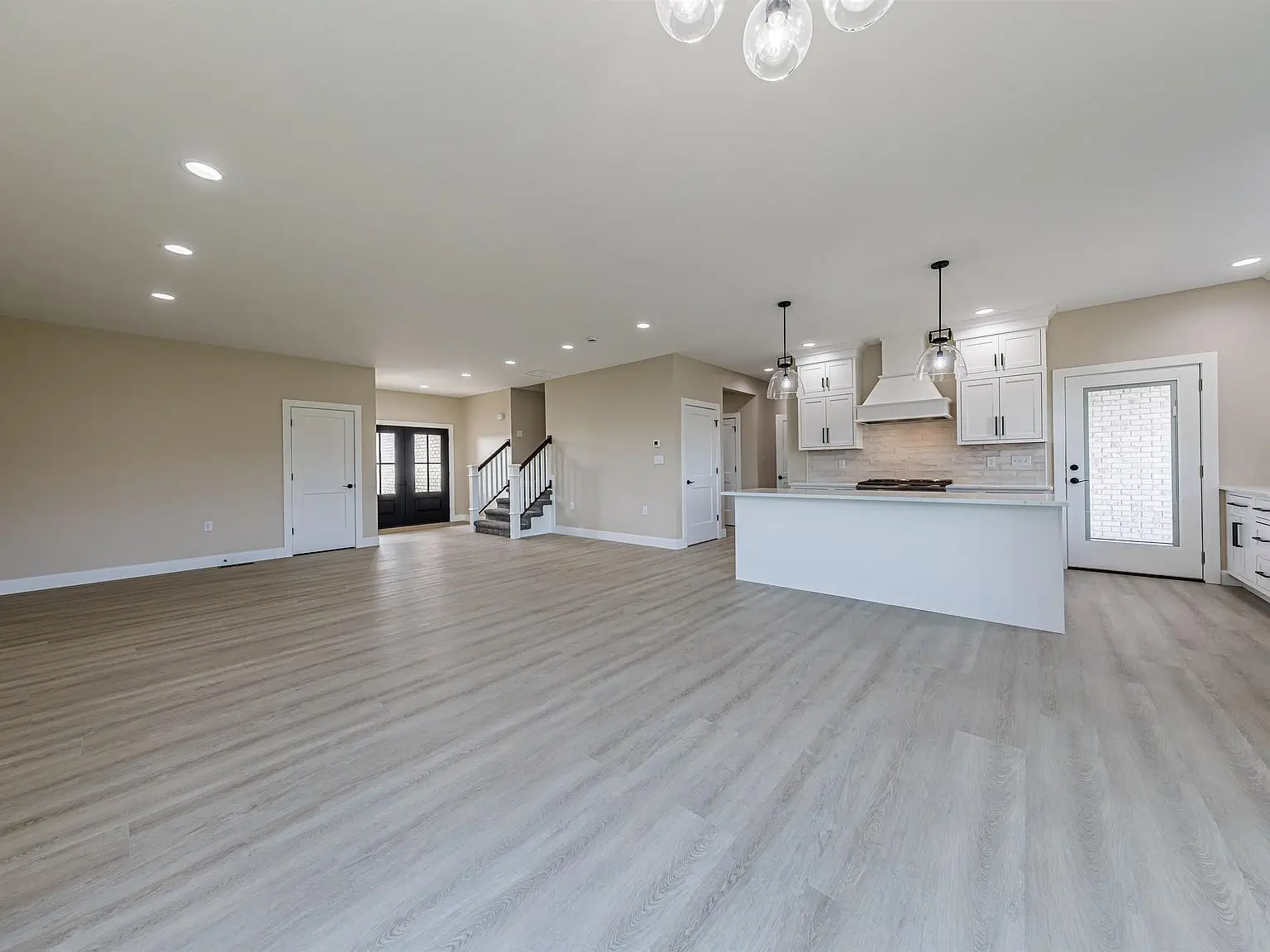 Spacious DaVinci floor plan with open kitchen, light wood floors, and elegant white cabinets.