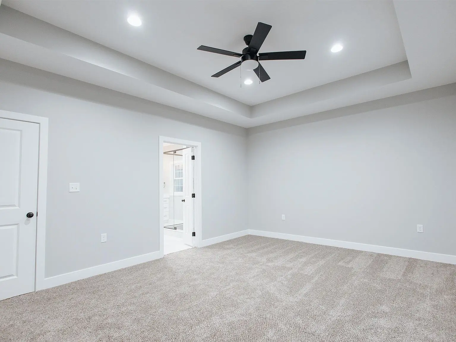 Spacious Eleanor floor plan with beige carpet, gray walls, ceiling fan, and bath access.