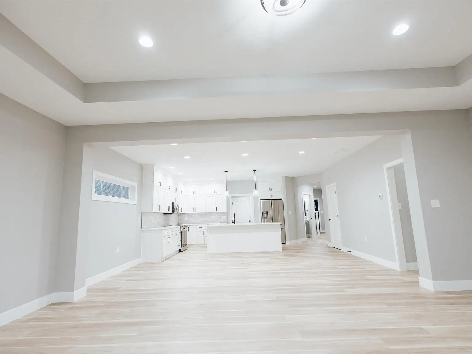 Spacious modern kitchen in the Eleanor home with light wood floors and recessed lighting.