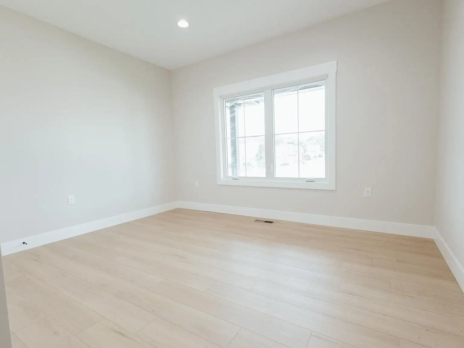 Bright Harper floor plan room with light wood floors, beige walls, and natural light.