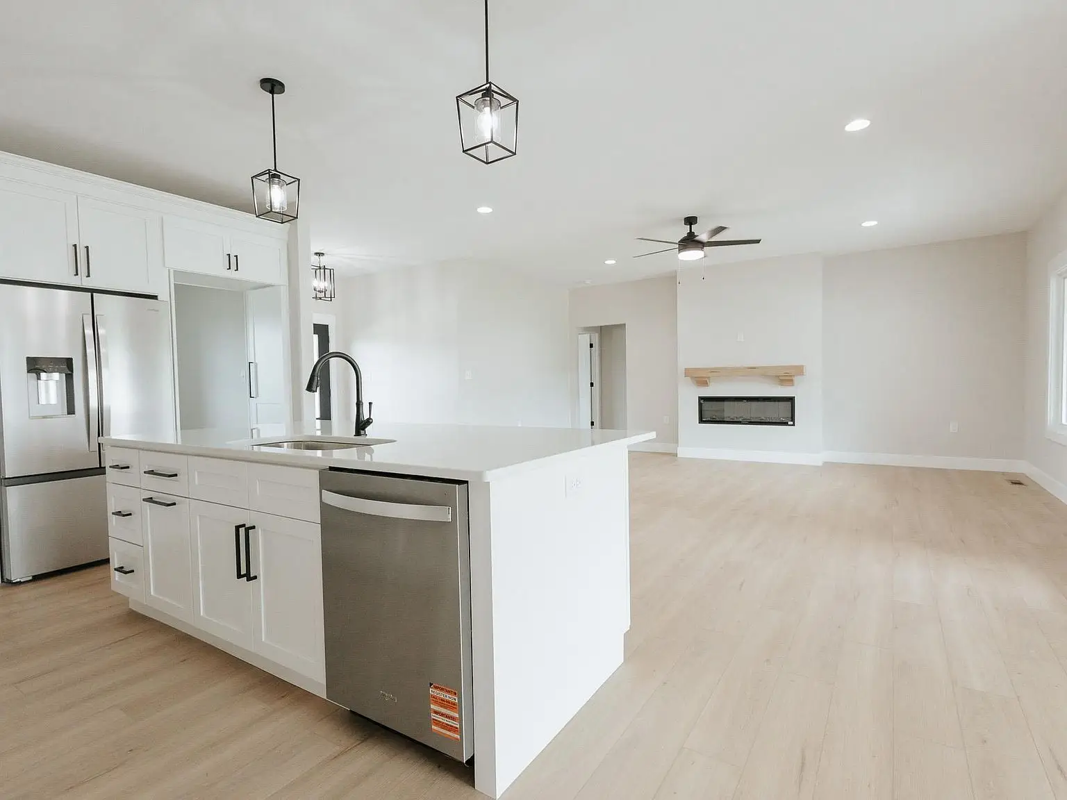 Modern Harper home kitchen with white cabinets, island, and open living area.