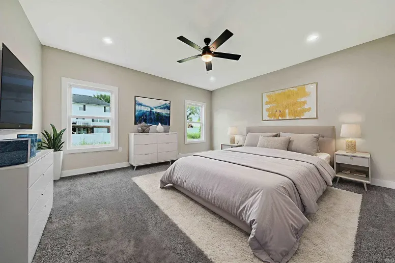 Modern bedroom with gray carpet, light walls, a king bed with gray bedding, white dressers, large windows, a ceiling fan, and wall art above the bed—perfect inspiration for your next blog on contemporary home design.