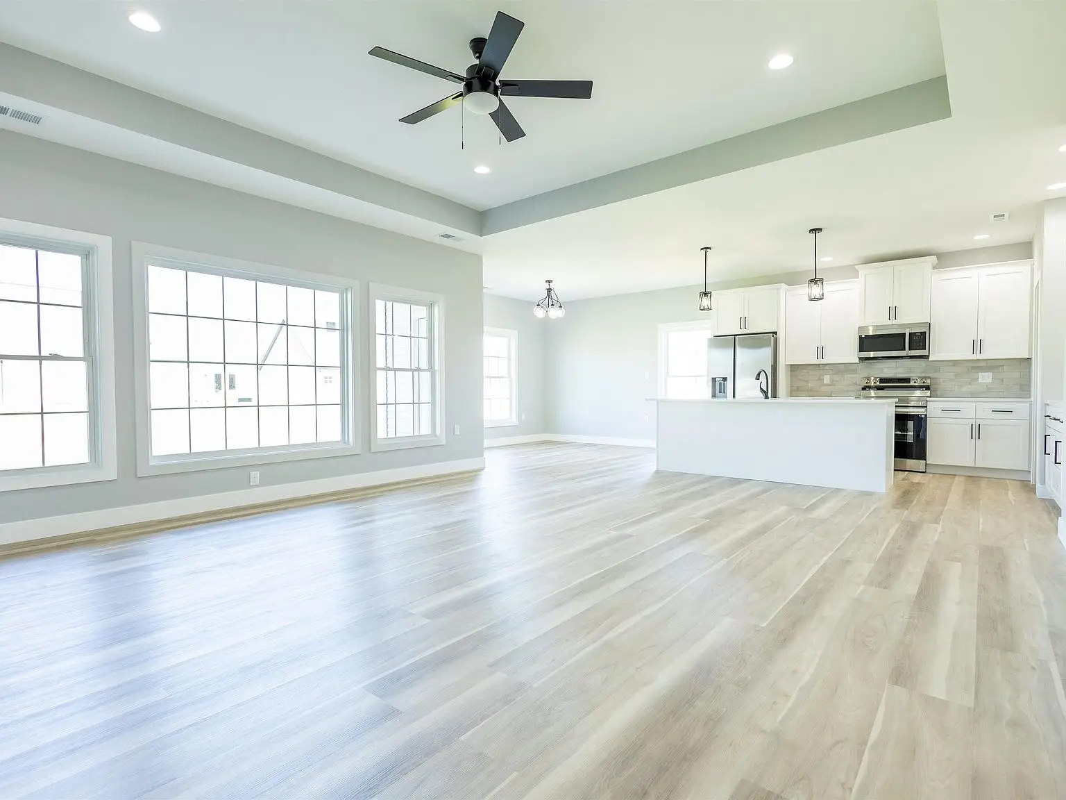 Spacious modern open-plan kitchen in Chris Brown Homes 1624 Eli Dr with light wood flooring.