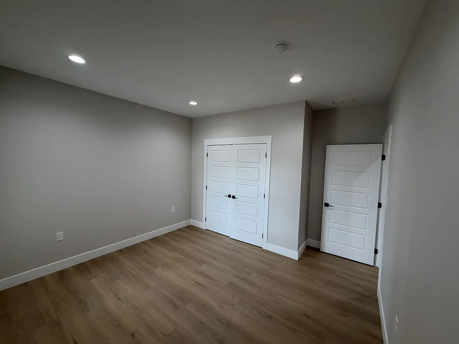 Empty room with wood flooring, gray walls—part of the Robin floor plan by Chris Brown Homes.