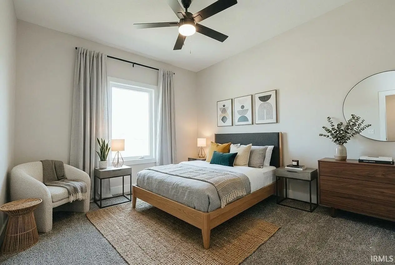 Modern Asher bedroom with bed, armchair, dresser, round mirror, and wall art.