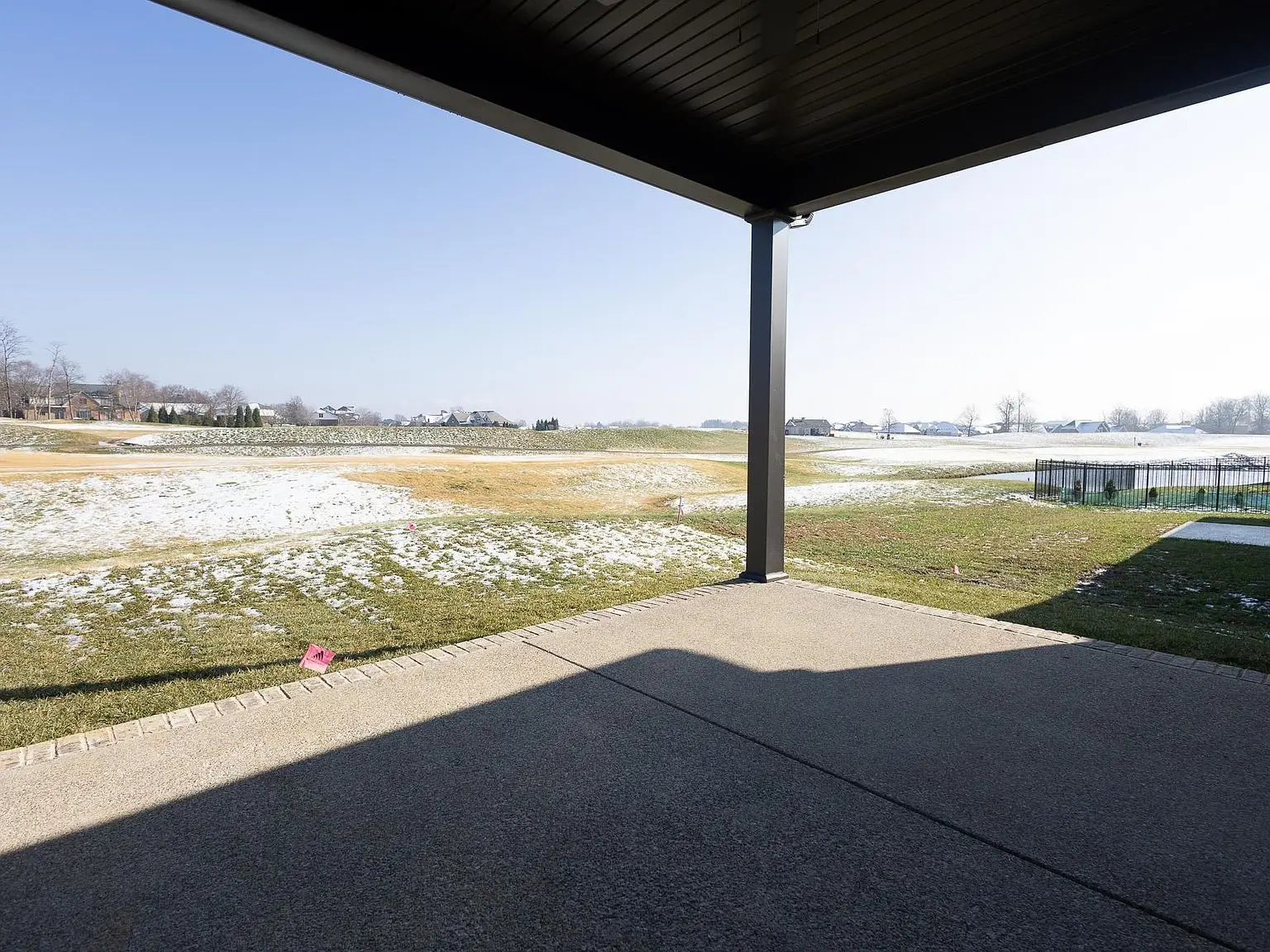 View from a covered patio of a snowy golf course, part of the Asher floor plan by Chris Brown Homes.
