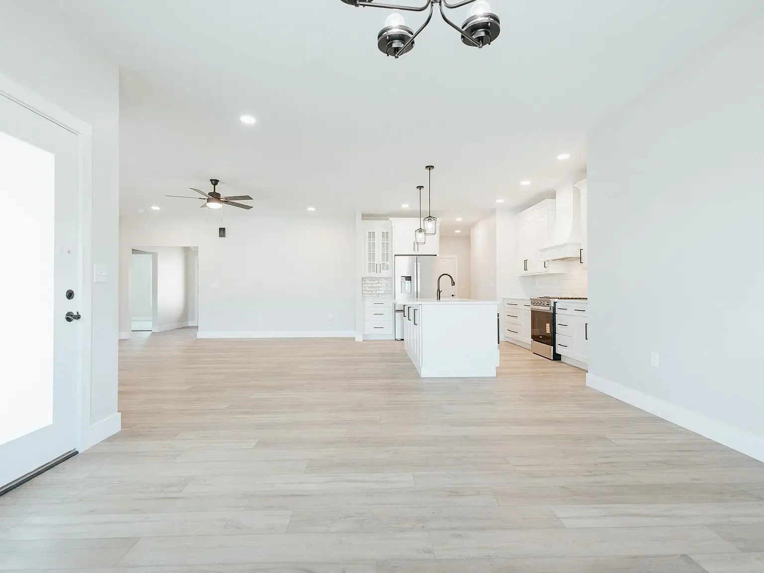 Spacious modern kitchen and living area featured in the Asher floor plan with light wood floors.