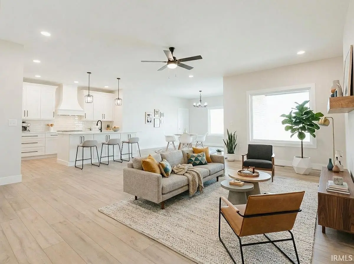 Open-plan Asher floor plan living room and kitchen with modern decor, neutral tones, wood floors.