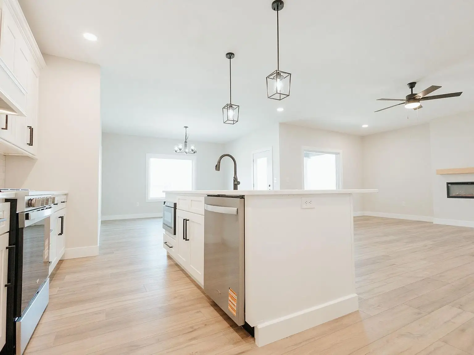 Modern kitchen in the Asher floor plan with island, pendant lights, and light wood floors.