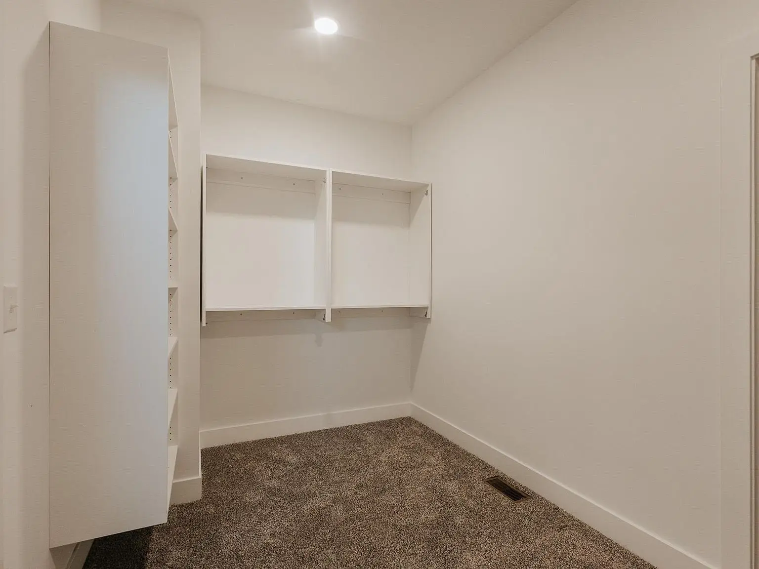 Empty Asher floor plan room: beige carpet, two shelves, white cabinet on left.