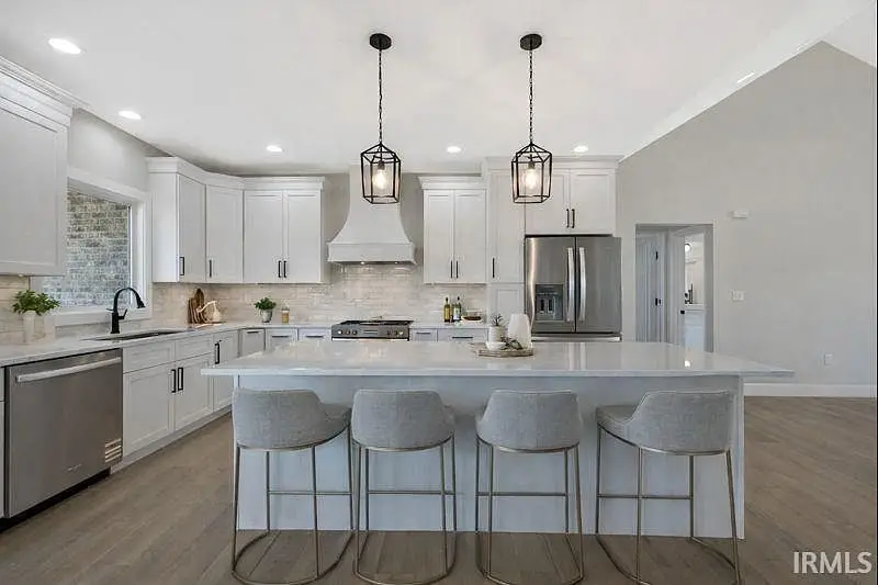 Modern kitchen in the Ava floor plan with white cabinets, island, and stainless steel appliances.
