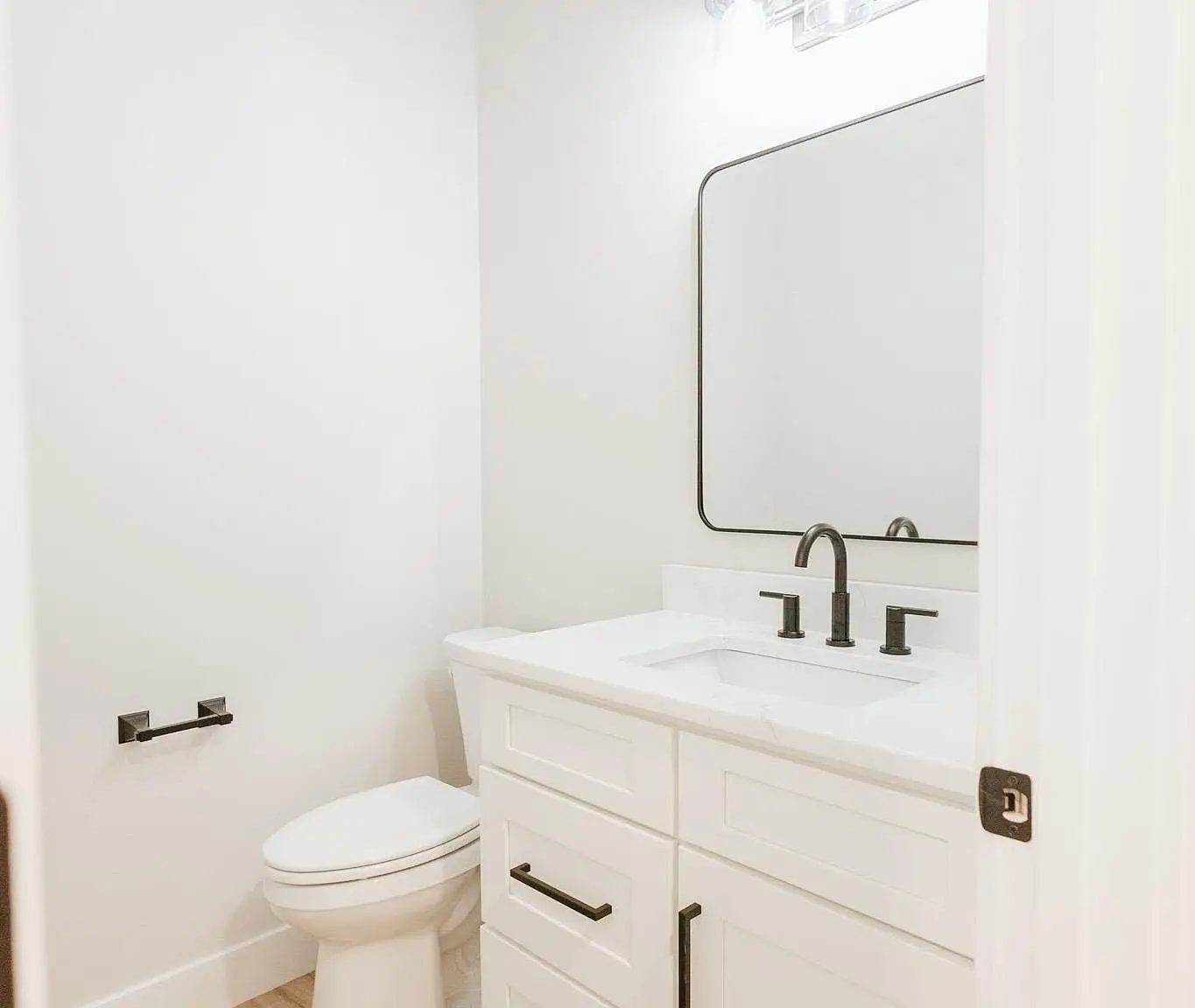White bathroom with Asher floor plan, black fixtures, large mirror, and sleek modern touches.