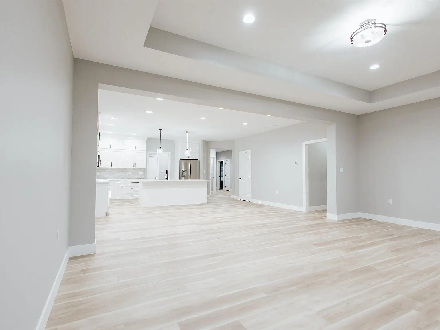 Spacious open-plan room in the Eleanor floor plan with light wood floors and a modern kitchen.