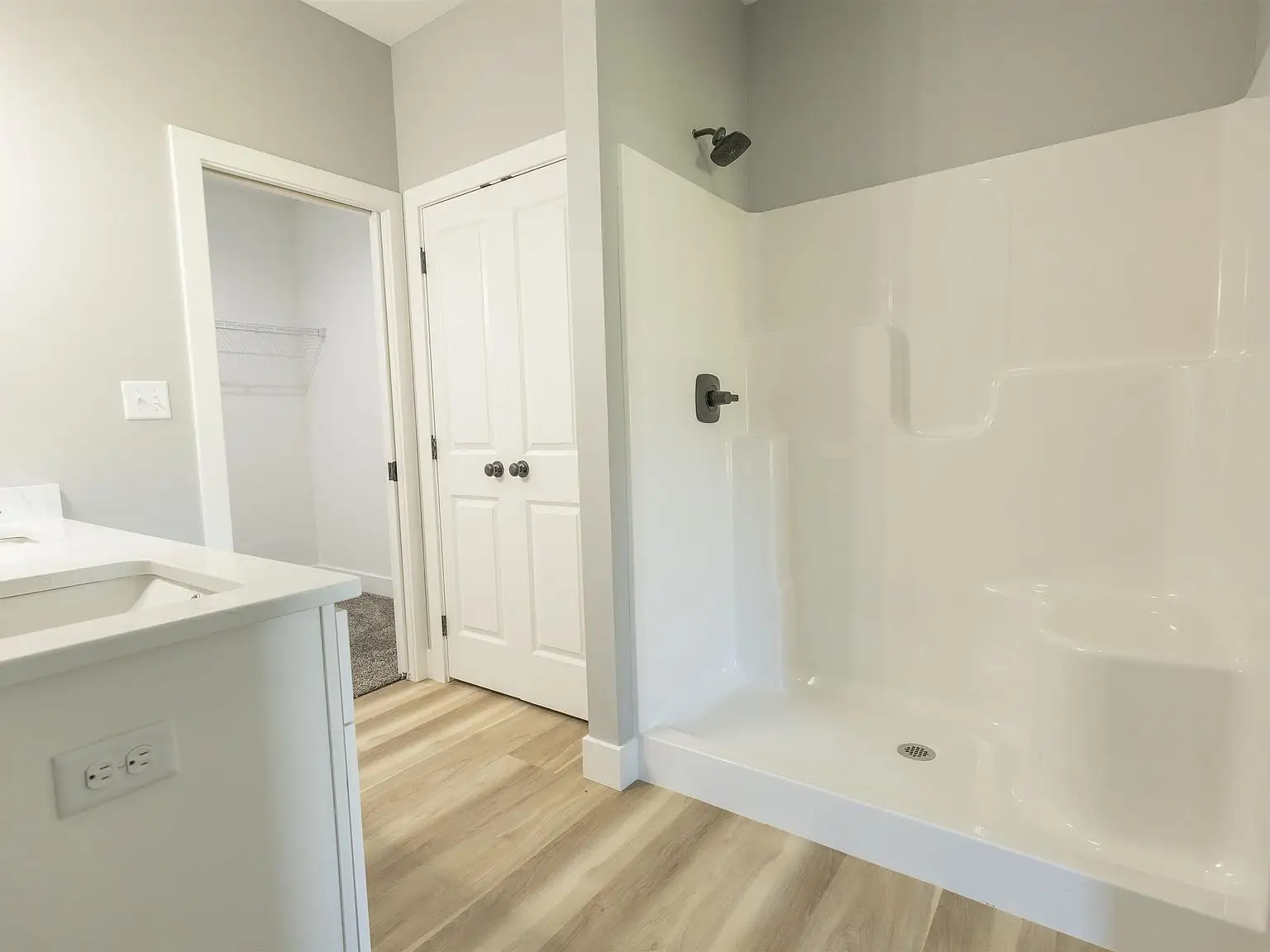 Bathroom in Chris Brown Homes 1624 Eli Dr features light wood floors and open closet door.