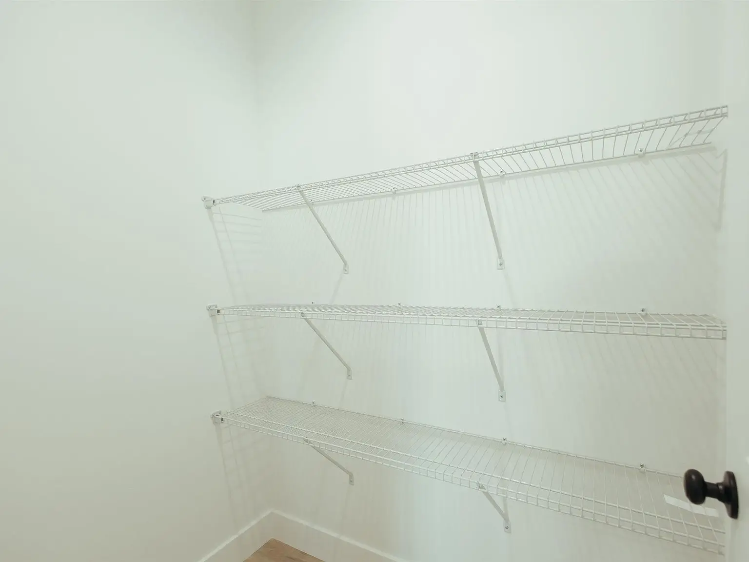 Spacious white closet with wire shelves and wood floor in the Kirkwood floor plan.