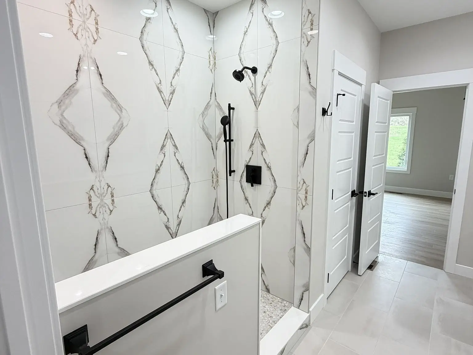Modern bathroom in the Chris Brown Homes Robin floor plan with walk-in shower and black fixtures.