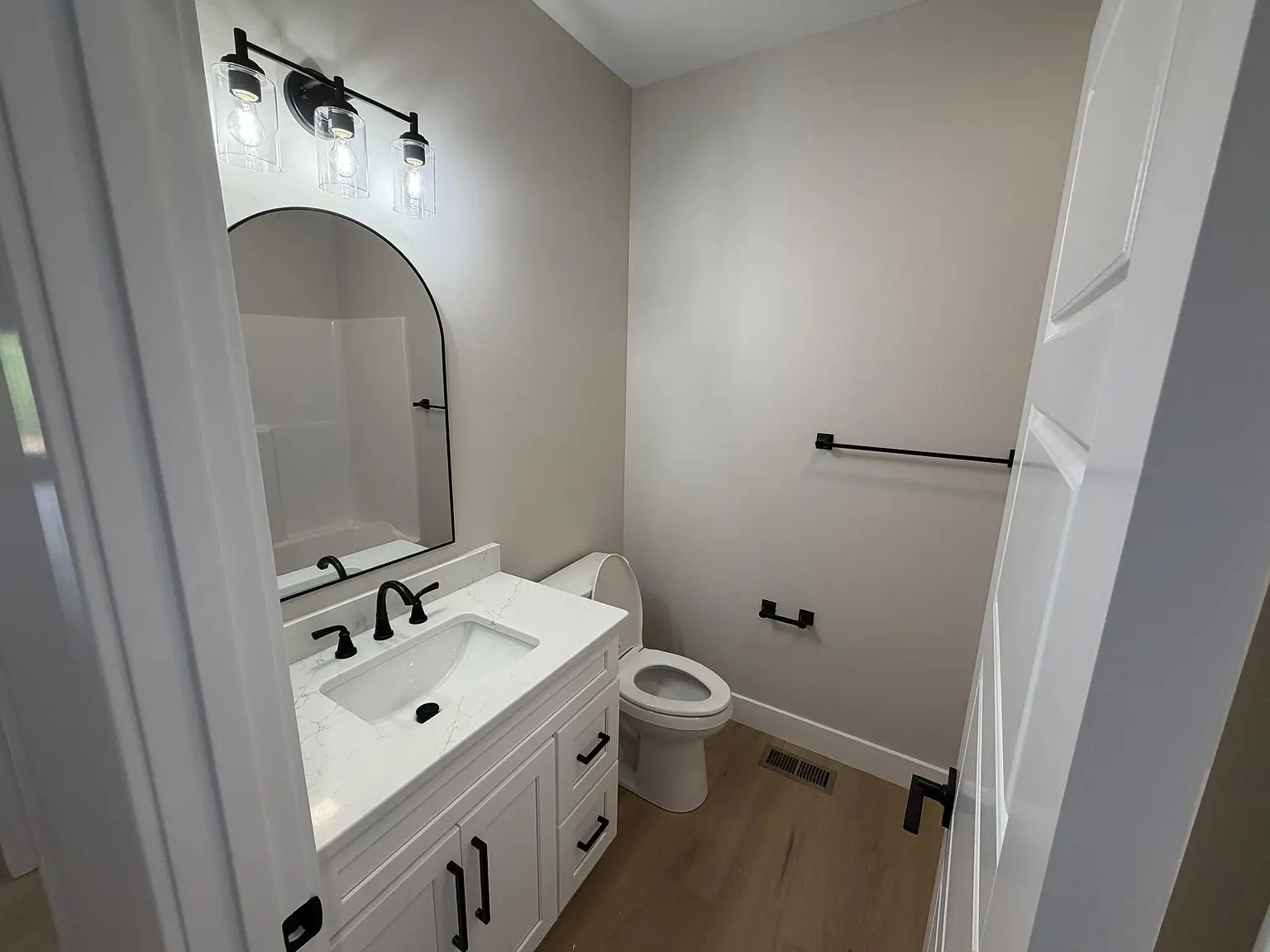 Modern bathroom with white vanity, black fixtures, and light wood flooring in the Robin floor plan.