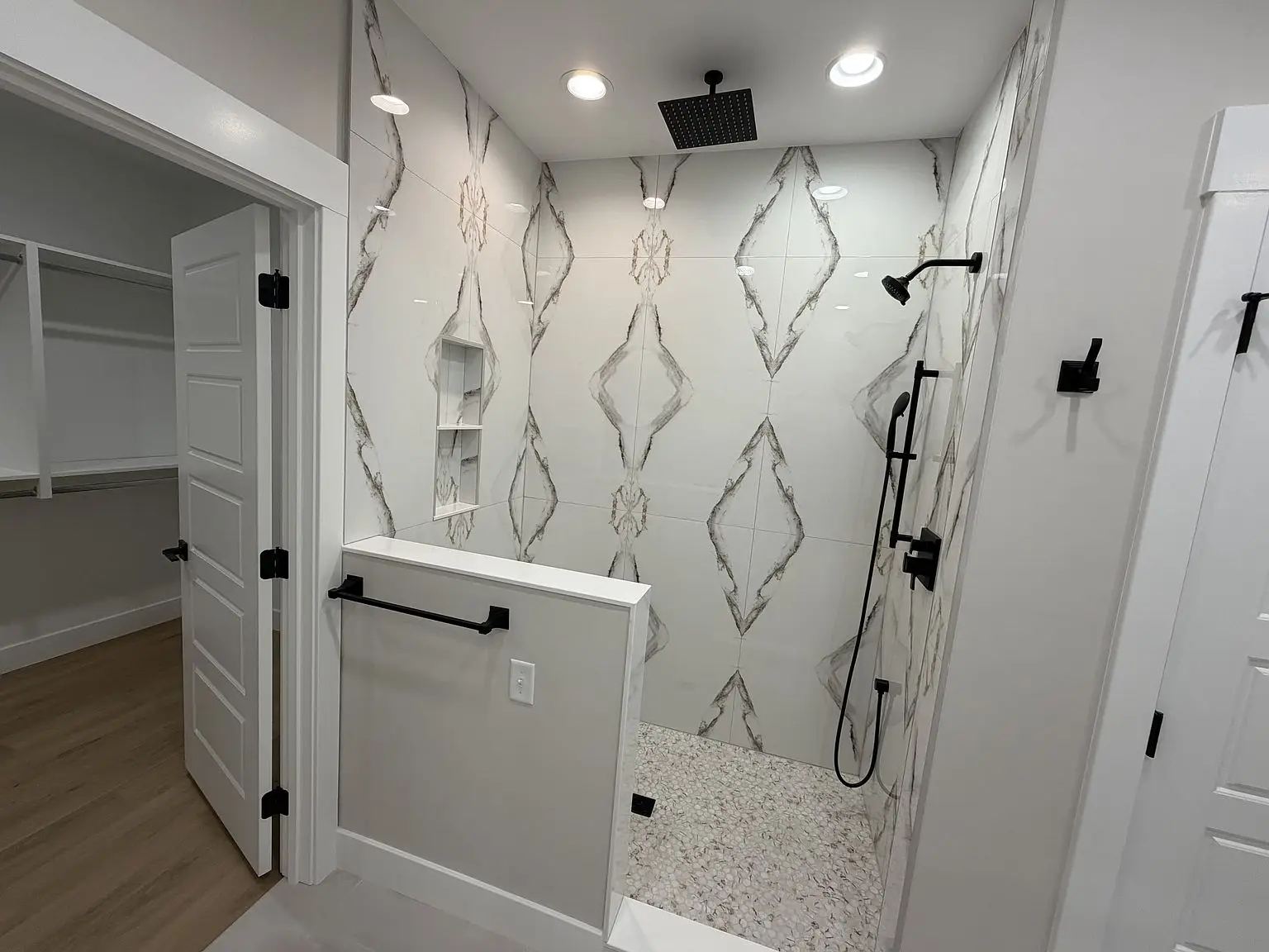 Modern walk-in shower with marble-patterned tiles, black fixtures, and Robin floor plan features.