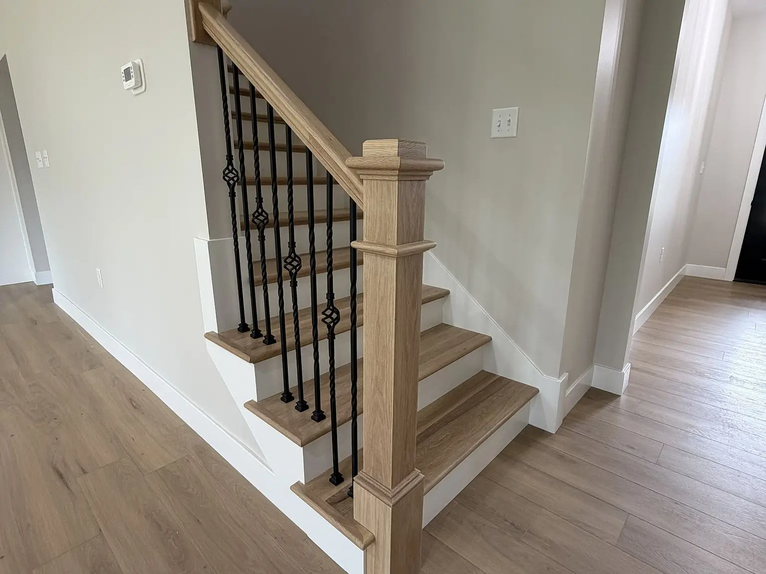 Modern interior with Robin floor plan: wooden stairs, black railings, and beige walls throughout.
