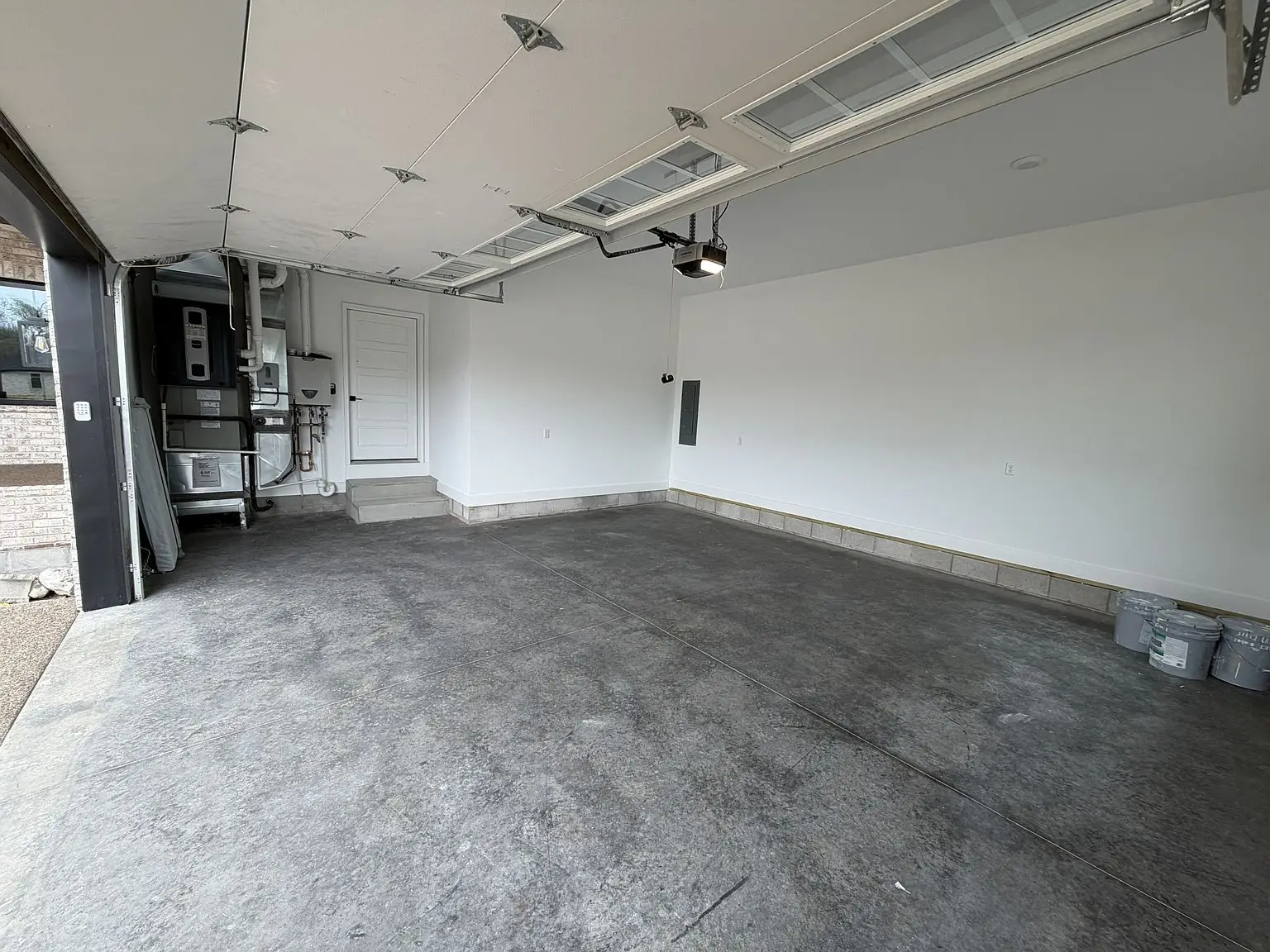 Spacious two-car garage in the Robin floor plan, with concrete floors and white walls.