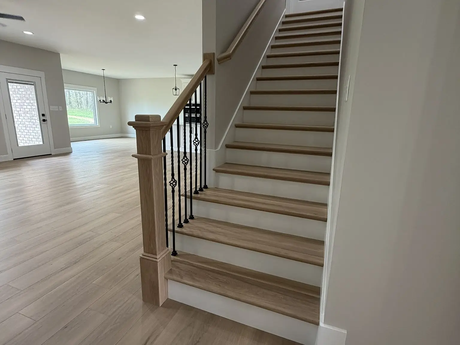 Wooden staircase with black balusters in a Robin floor plan by Chris Brown Homes, 6192 Ashford Cir.