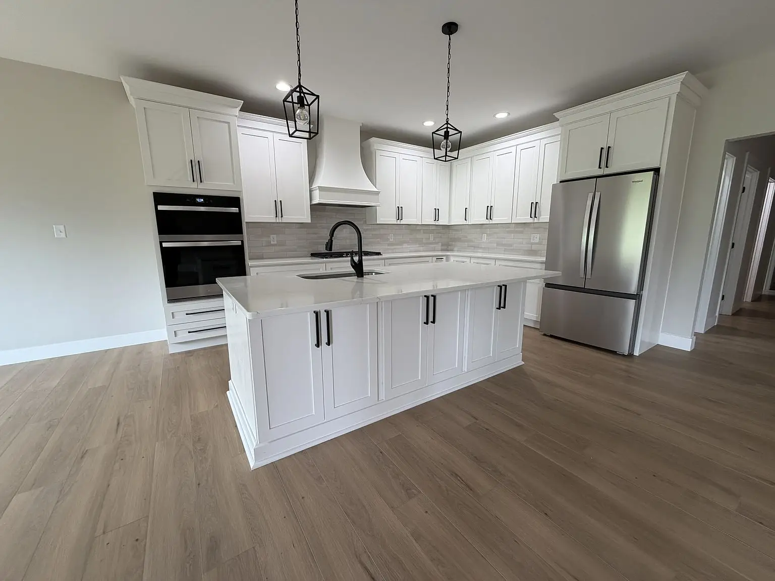 Modern kitchen in the Robin floor plan with white cabinets, island, and stainless appliances.