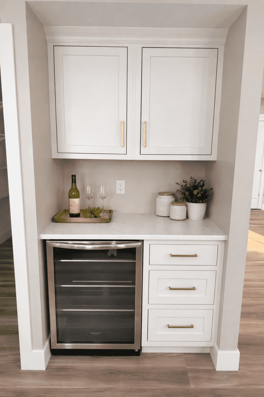 Built-in beverage station with wine cooler and white cabinetry at 18800 Wicklow Way, Aurora.