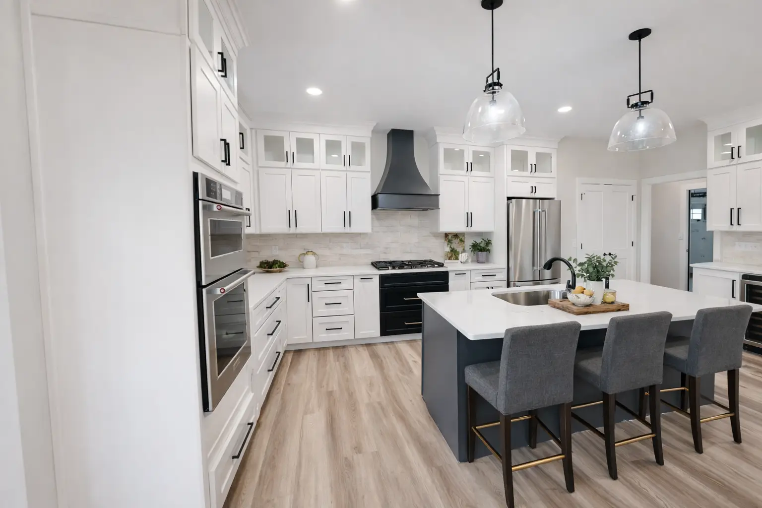 Aurora kitchen at Chris Brown Homes with white cabinets, black hood, and gray island.