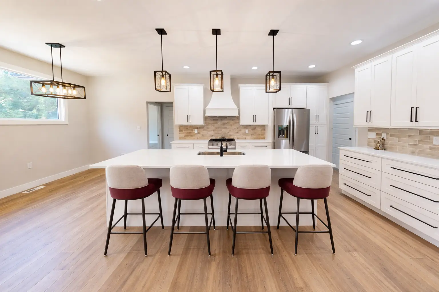 Sophia kitchen by Chris Brown Homes with white island, pendant lights, and stainless appliances.