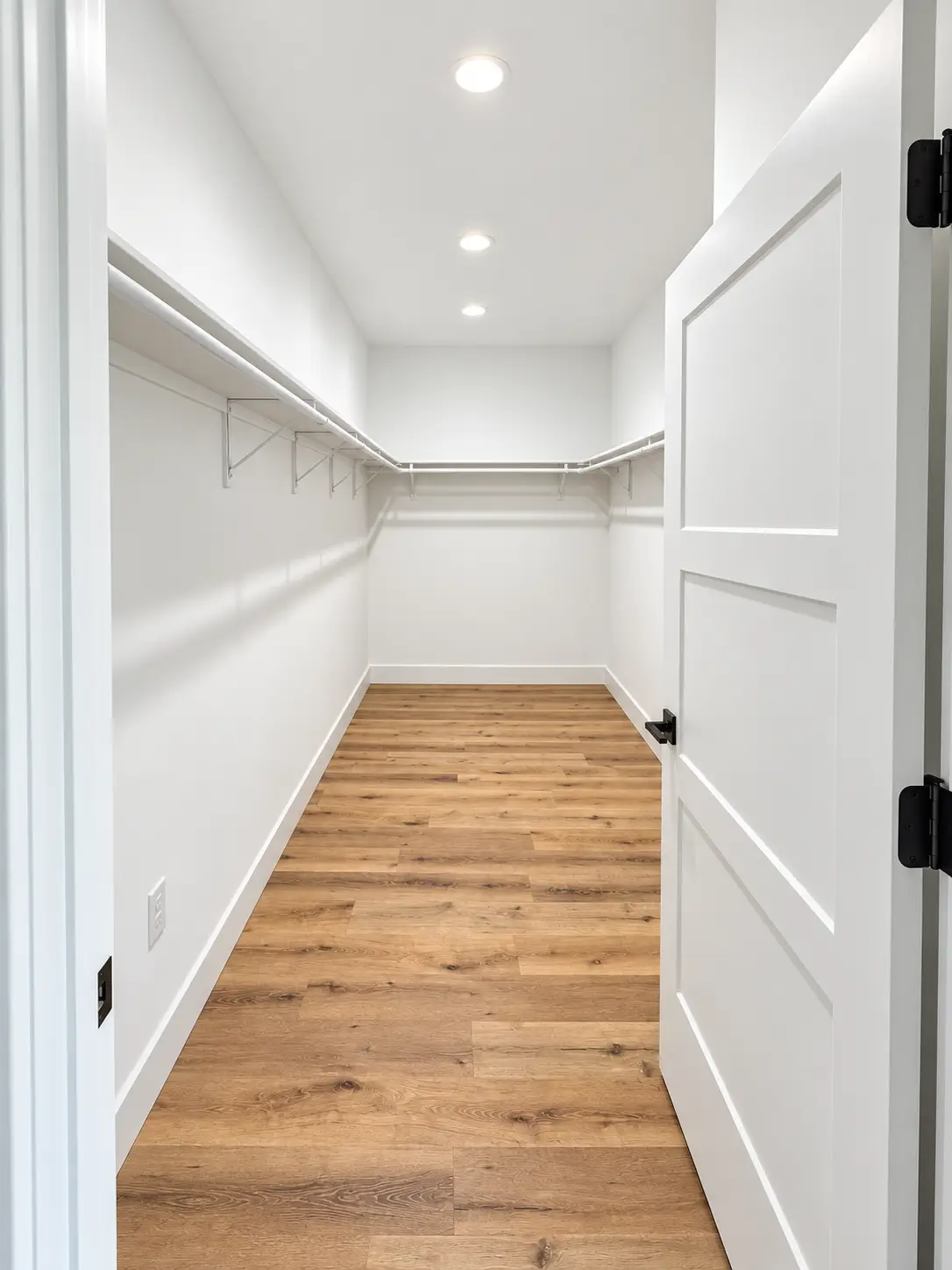 Bright Kirkwood Walk-In Closet With Wood Flooring