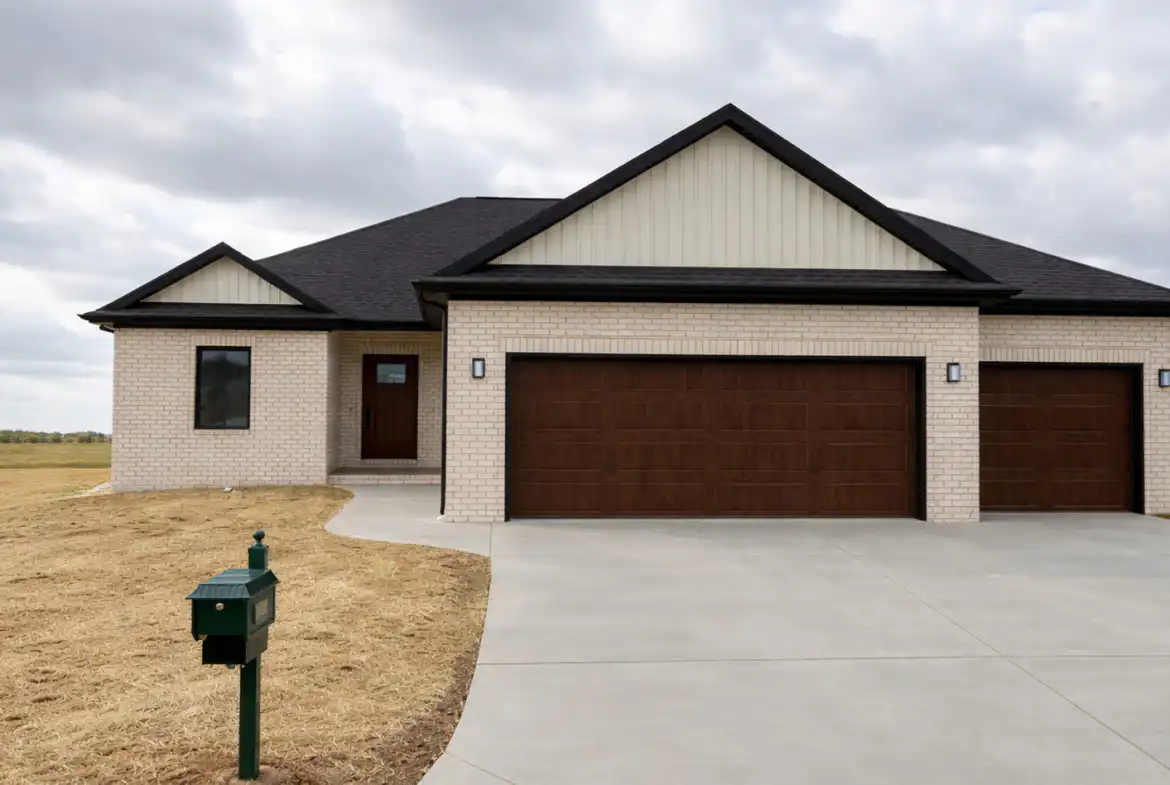 Modern Leo single-story brick house with dark roof, three-car garage, and concrete driveway.