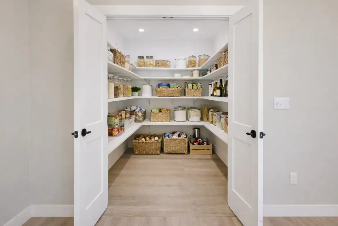 Move-in-ready Asher floor plan walk-in pantry with white shelves and woven baskets.