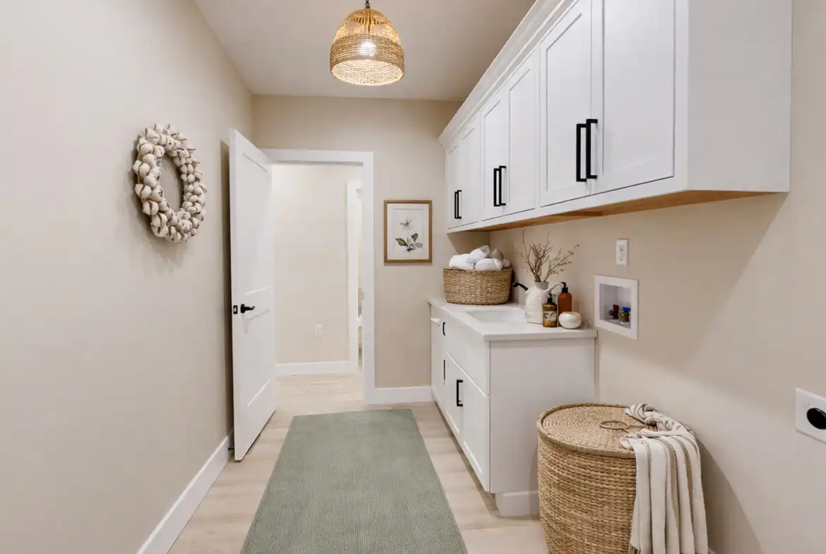 Move-in-ready Asher laundry room at 5622 Lenox Drive with white Shaker cabinets and sage runner.