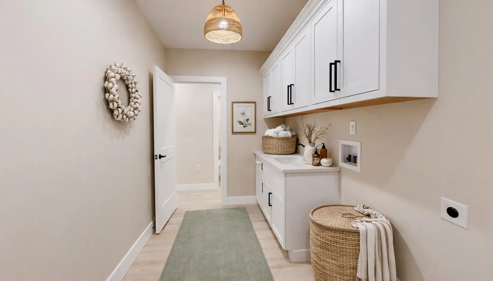 Move-in-ready Asher laundry room at 5622 Lenox Drive with white Shaker cabinets and sage runner.